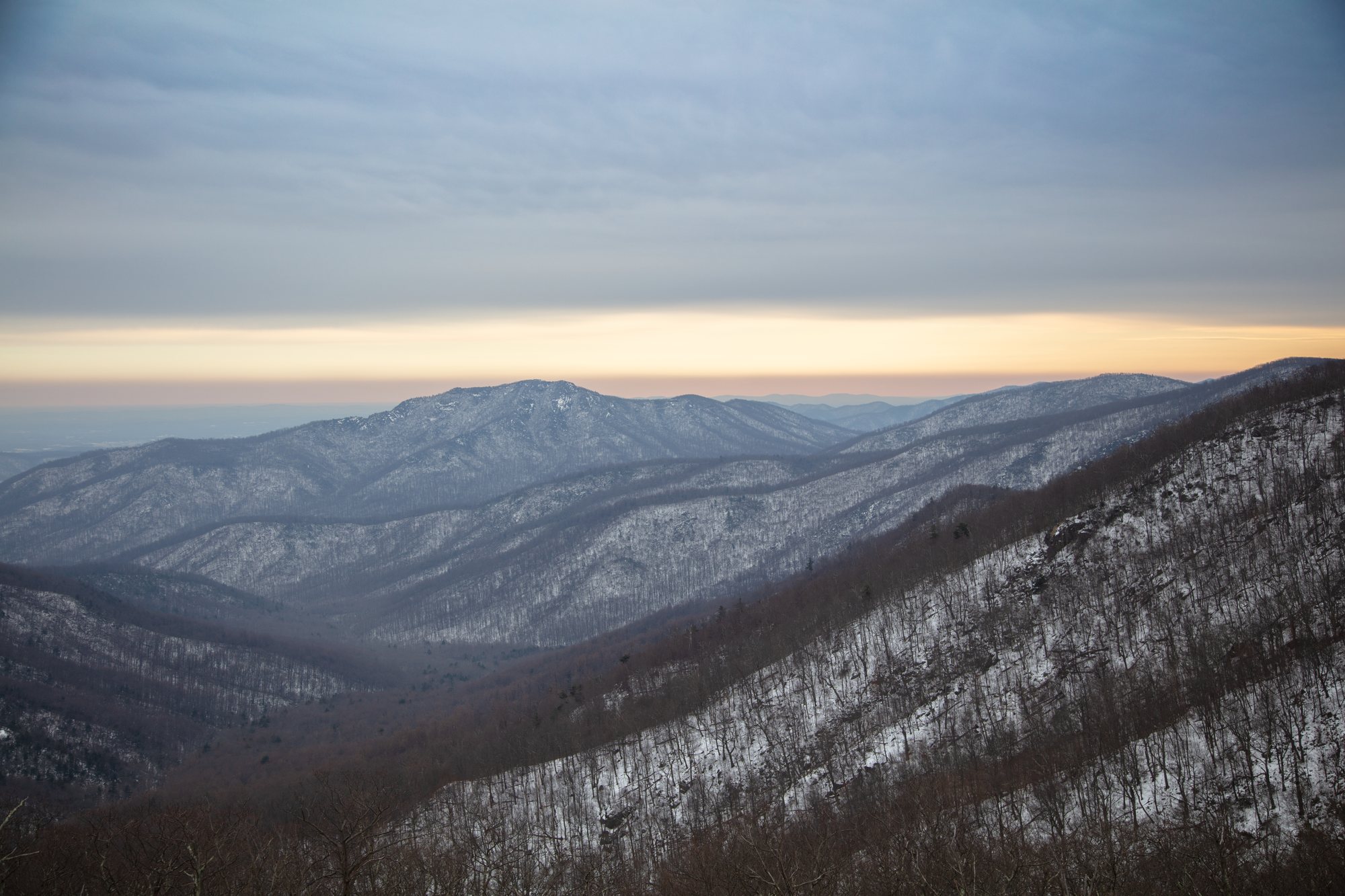 A layered Blue Ridge view from a west-facing Skyline Drive overlook in Shenandoah, ridgelines fading into haze toward the Shenandoah Valley